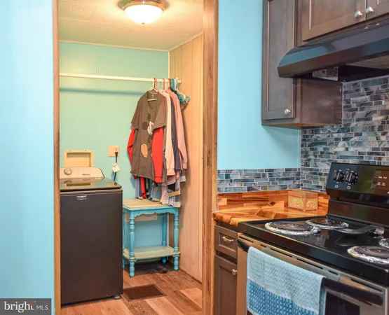 a kitchen with stainless steel appliances granite countertop a refrigerator a sink dishwasher a stove and a dining table with wooden floor