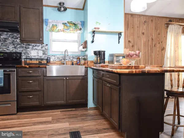 a kitchen with stainless steel appliances granite countertop a refrigerator a stove a sink and a microwave