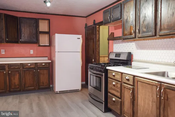 a kitchen with stainless steel appliances a refrigerator and a stove top oven