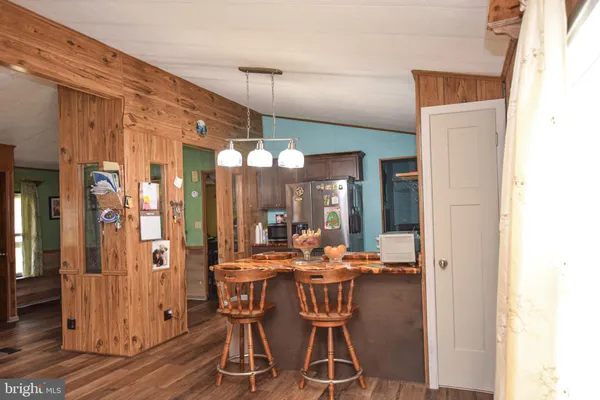 a kitchen with stainless steel appliances granite countertop a refrigerator a stove and a sink with wooden floor