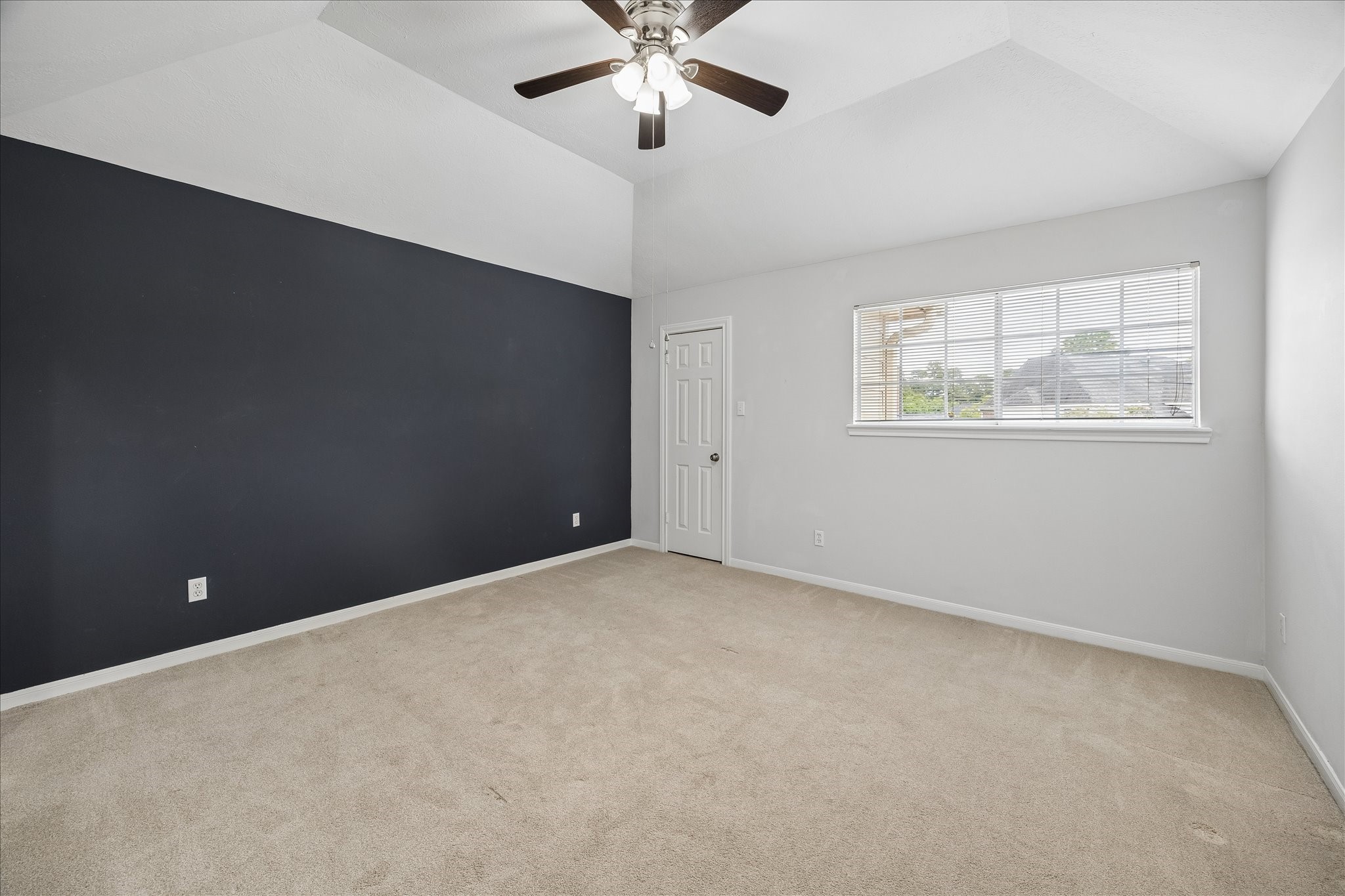 7915 Huddersfield Court Spring, TX 77379 - Photo 28 of 37 Secondary bedroom with vaulted ceiling, generous natural light, and a bold accent wall that adds character to the space.