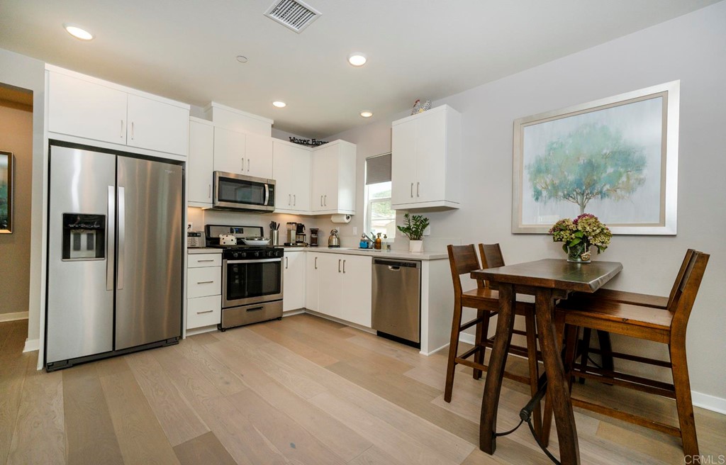 835 Blackstone Drive San Marcos, CA 92078 - Photo 6 of 30 a kitchen with refrigerator a sink and chairs