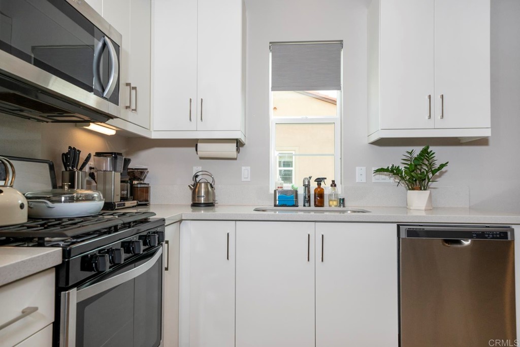 835 Blackstone Drive San Marcos, CA 92078 - Photo 7 of 30 a kitchen with granite countertop a sink stainless steel appliances and white cabinets