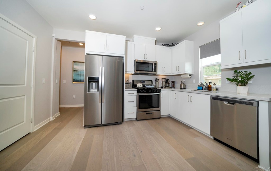 835 Blackstone Drive San Marcos, CA 92078 - Photo 8 of 30 a kitchen with a refrigerator a sink and cabinets