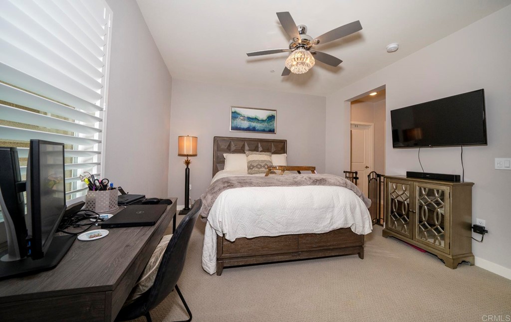 835 Blackstone Drive San Marcos, CA 92078 - Photo 9 of 30 a spacious bedroom with a bed a flat screen tv and a chandelier