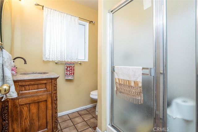 a bathroom with a granite countertop sink a toilet and a mirror