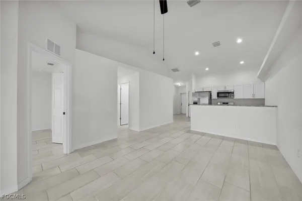 a view of kitchen with kitchen island white cabinets and refrigerator