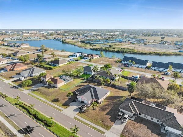 an aerial view of a house with a yard and lake view
