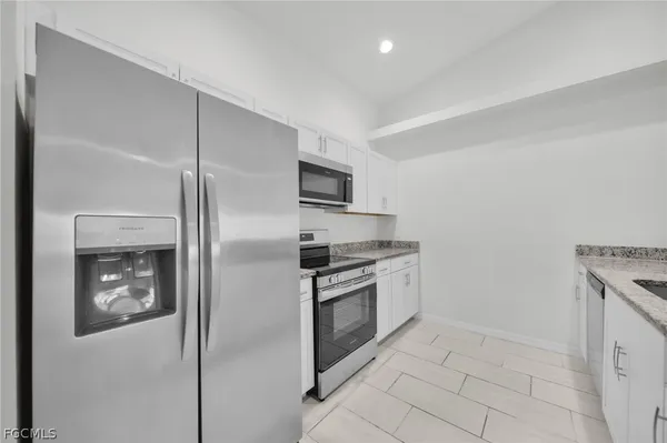 a kitchen with stainless steel appliances granite countertop a refrigerator and a stove top oven