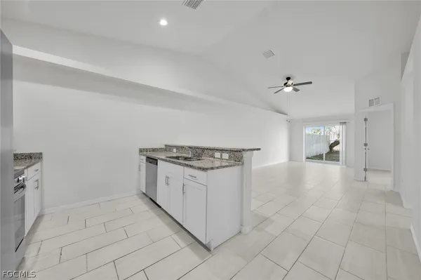 a view of a kitchen with furniture and an empty room