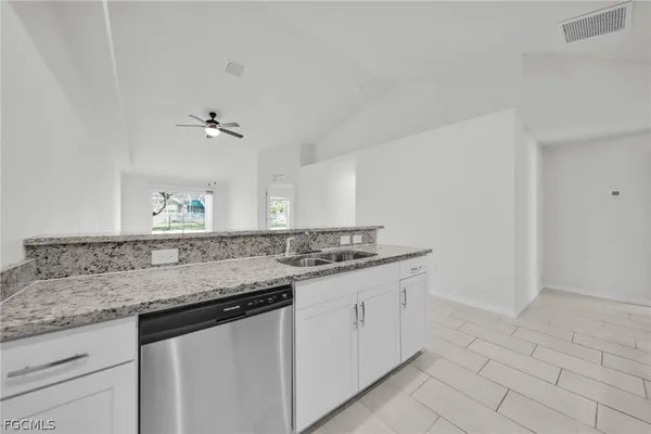 a kitchen with granite countertop a sink and a white stove