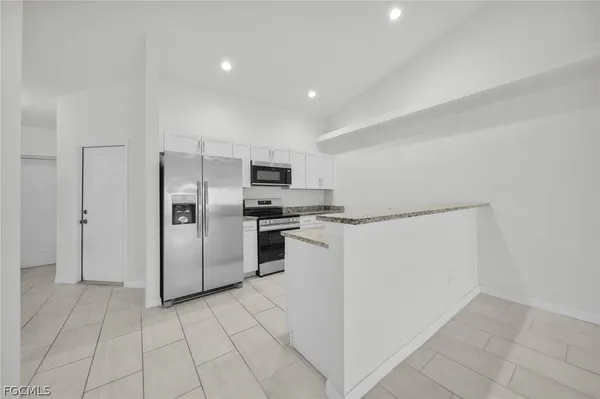 a kitchen with stainless steel appliances a refrigerator and a stove top oven