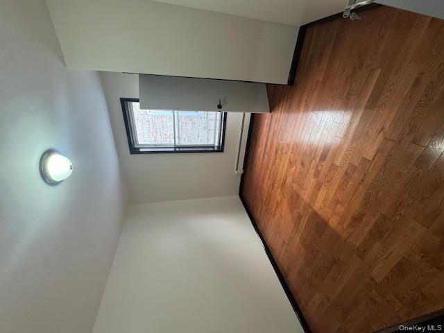 1586 Prospect Place, Unit 1R Brooklyn, NY 11233 - Photo 3 of 7 an empty room with wooden floor and windows