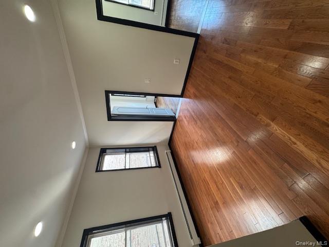 1586 Prospect Place, Unit 1R Brooklyn, NY 11233 - Photo 4 of 7 a view of an empty room with wooden floor and a window