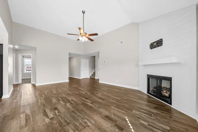 a view of empty room with wooden floor and fireplace