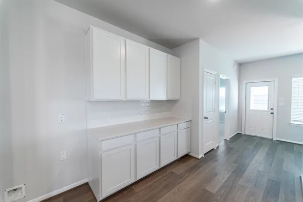 a view of an empty room with wooden floor and closet