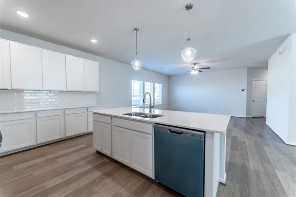 a kitchen with granite countertop a sink cabinets and wooden floor