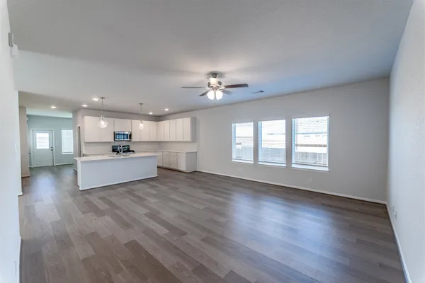 a view of a big room with wooden floors and a kitchen