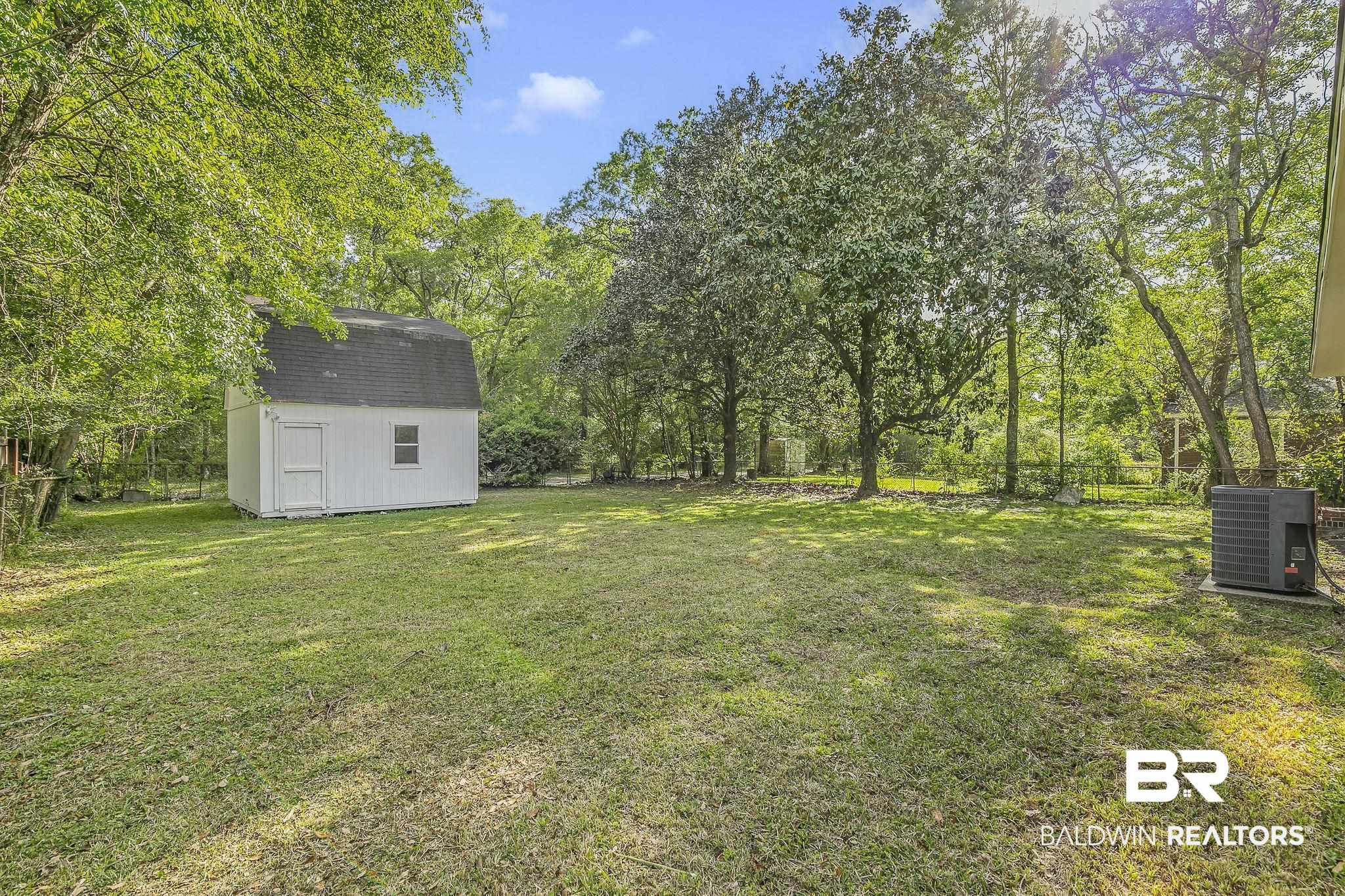 203 Anderson Road Saraland, AL 36571 - Photo 36 of 48 View of yard featuring a shed, central air condition unit, fence, and an outbuilding