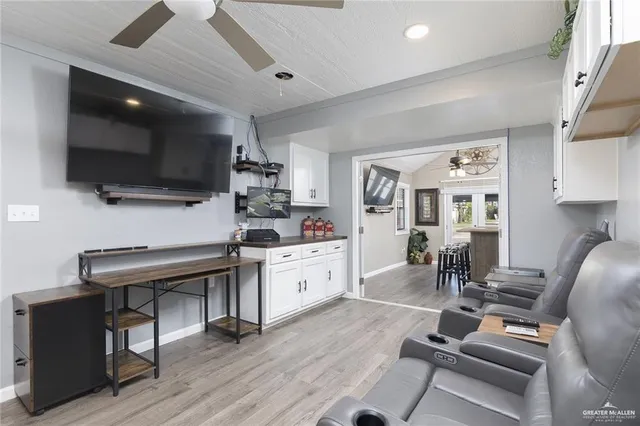 a living room with furniture a flat screen tv and kitchen view