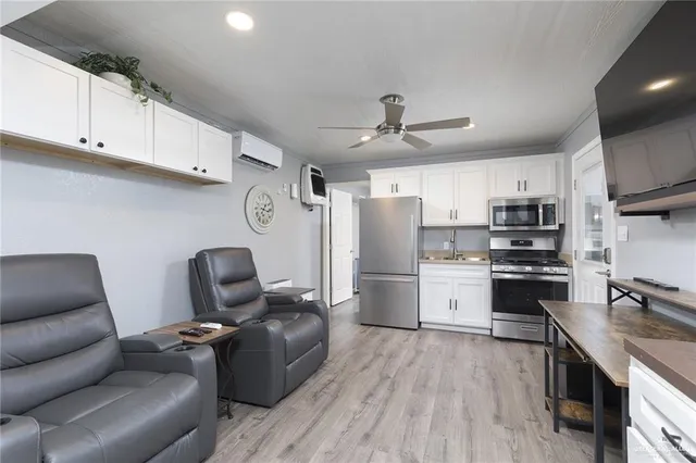 a living room with stainless steel appliances kitchen island granite countertop a couch and a view of kitchen