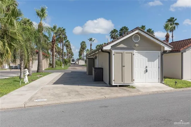 a view of a house with a yard and large tree