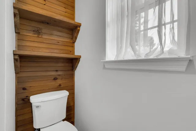 a bathroom with a toilet and a window