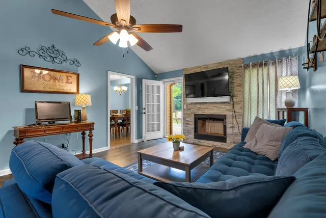 a living room with furniture a flat screen tv and a fireplace