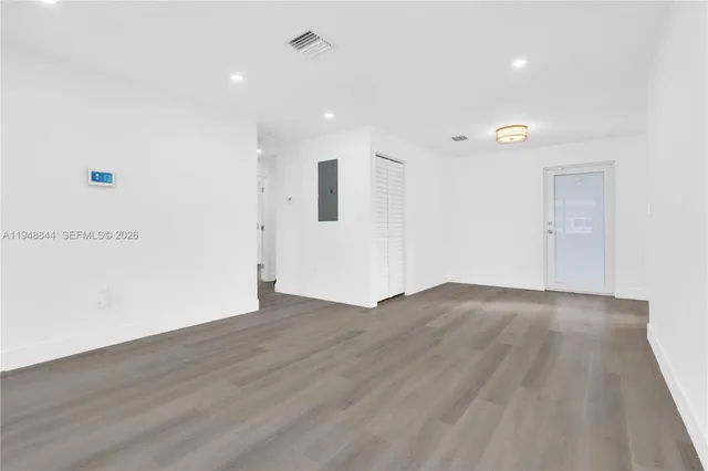 a view of an empty room with wooden floor