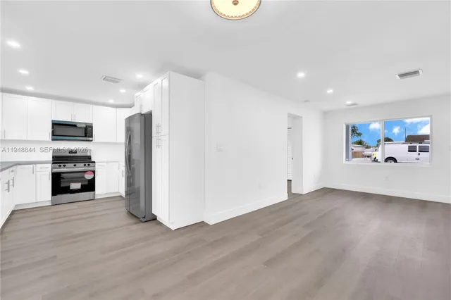 a view of a kitchen with a sink refrigerator and a cabinets
