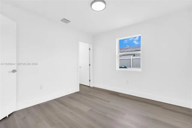 a view of a room with wooden floor and white walls