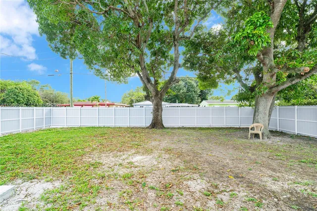 a view of a yard with a house and large trees
