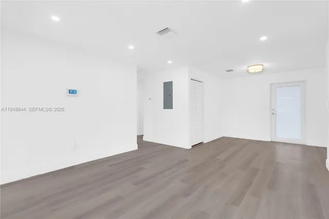 a view of an empty room with wooden floor