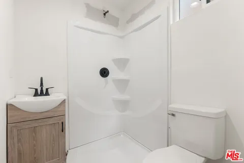 a bathroom with a sink a toilet and shower