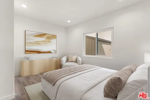 a bedroom with a bed and a painting on the wall