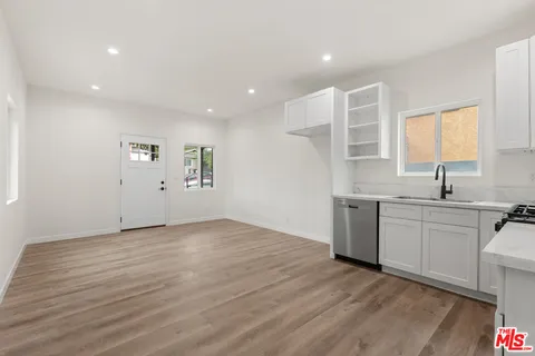 a view of a kitchen with a sink a refrigerator and window