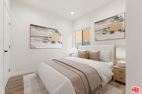 a bedroom with bed and wall painting with wooden floor