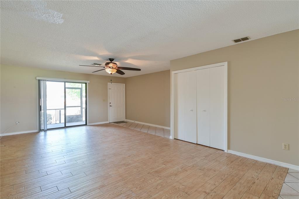 11001 Southeast Sunset Harbor Road, Unit H52 Summerfield, FL 34491 - Photo 15 of 31 a view of an empty room with chandelier fan and wooden floor