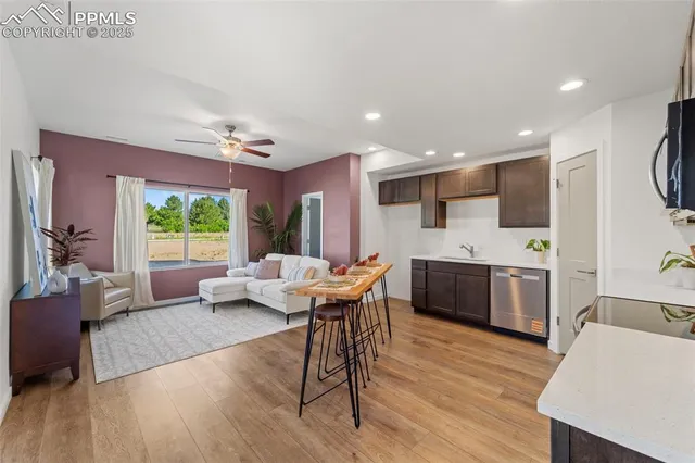 a living room with furniture a wooden floor and a large window