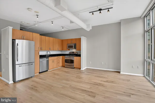 a kitchen with stainless steel appliances a refrigerator and wooden floor