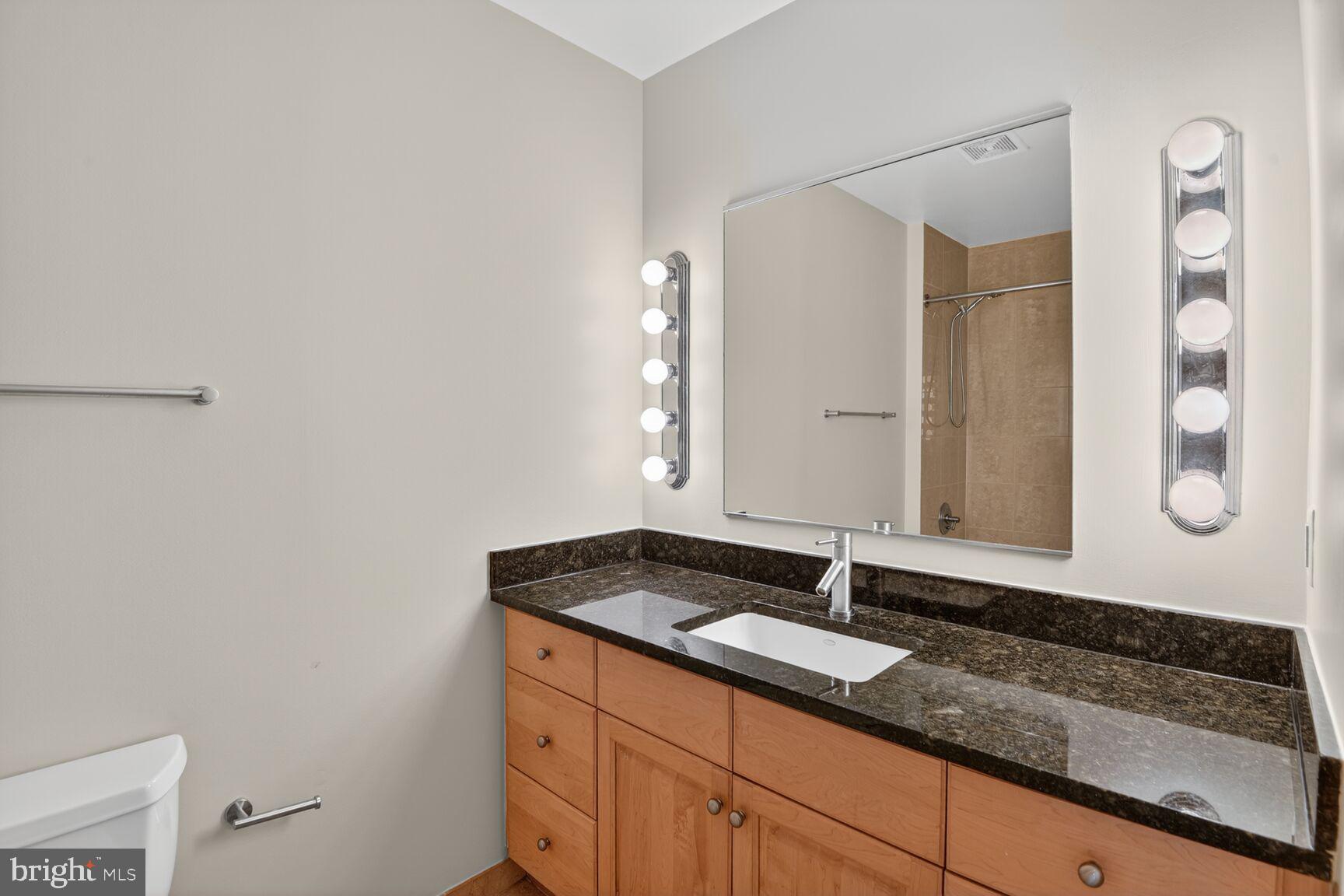 811 4th Street Northwest, Unit 503 Washington, DC 20001 - Photo 6 of 15 a bathroom with a granite countertop sink and a mirror