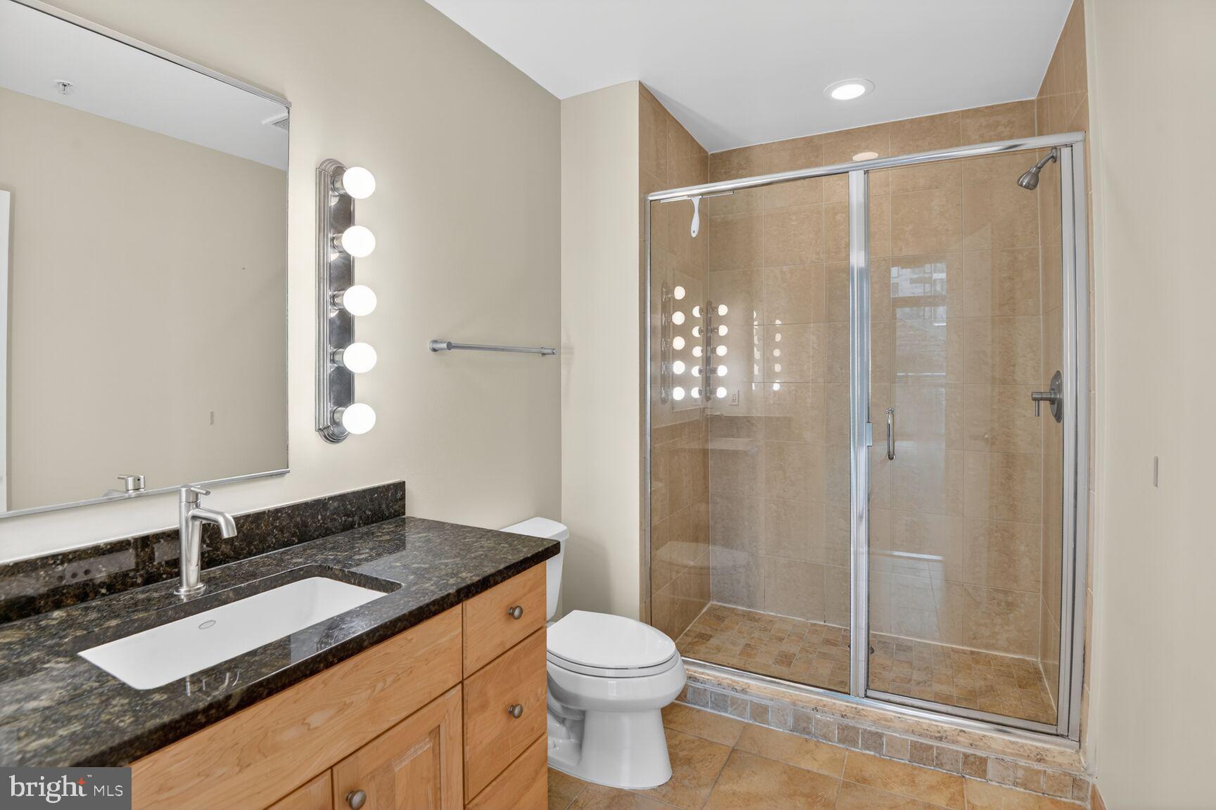 811 4th Street Northwest, Unit 503 Washington, DC 20001 - Photo 7 of 15 a bathroom with a granite countertop sink toilet and shower