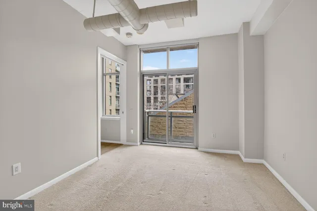 an empty room with windows and closet