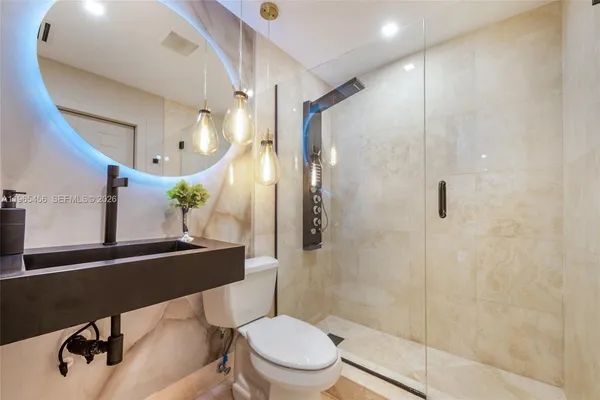 a bathroom with a sink mirror vanity and toilet