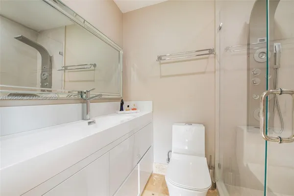 a bathroom with a sink a toilet and shower