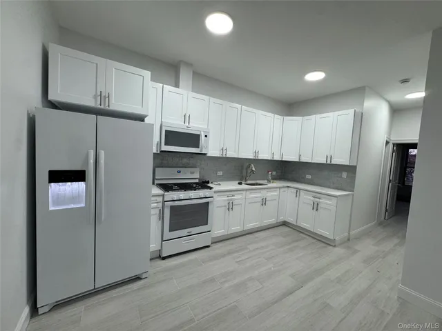 a kitchen with granite countertop white cabinets and stainless steel appliances