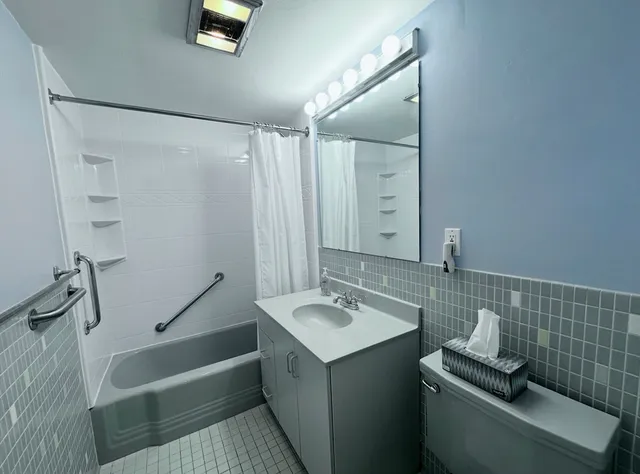 a bathroom with a tub sink and mirror