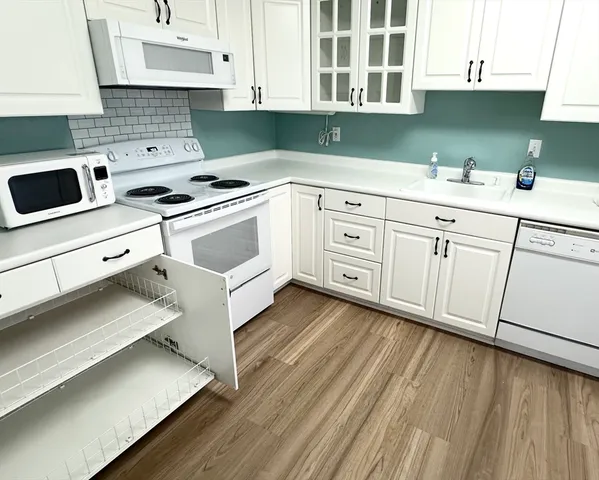 a kitchen with cabinets appliances and a sink