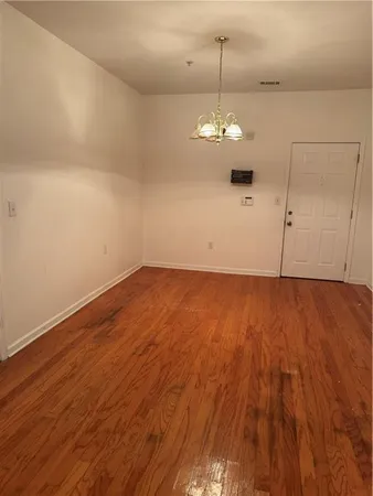 a view of a room with wooden floor and ceiling fan