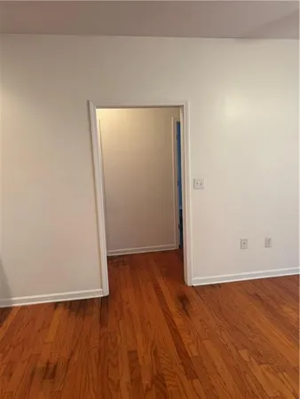 an empty room with wooden floor and closet
